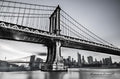 Black-and-white Manhattan Bridge spanning the East River, with New York buildings beyond. Photograph by Anders Jorulf.
