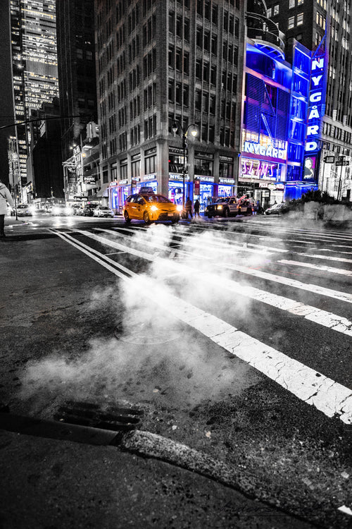 Steam rising from a New York street beneath tall buildings and blue illuminated signs. Photograph by Anders Jorulf.