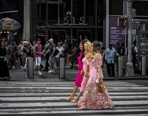 Two pedestrians in colourful clothing crossing a New York street against a darker urban background. Photograph by Anders Jorulf.