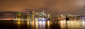 A wide panorama of illuminated Manhattan reflected in dark water. Photograph by Anders Jorulf.