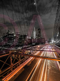 Vertical night view along Brooklyn Bridge with light trails and a city skyline. Photograph by Anders Jorulf.