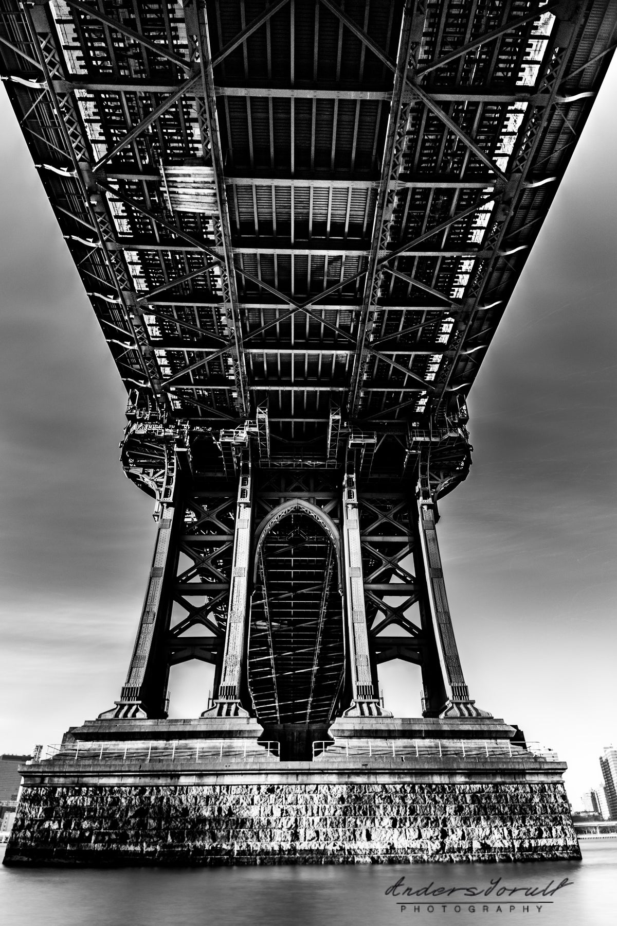 Black-and-white view beneath Manhattan Bridge in New York by Anders Jorulf