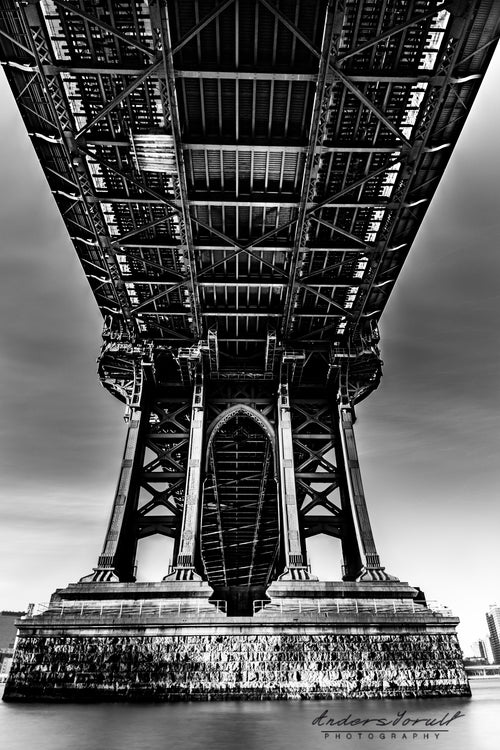 Black-and-white view beneath Manhattan Bridge in New York by Anders Jorulf