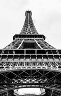 A black-and-white view looking upwards along the Eiffel Tower’s iron structure. Photograph by Anders Jorulf.