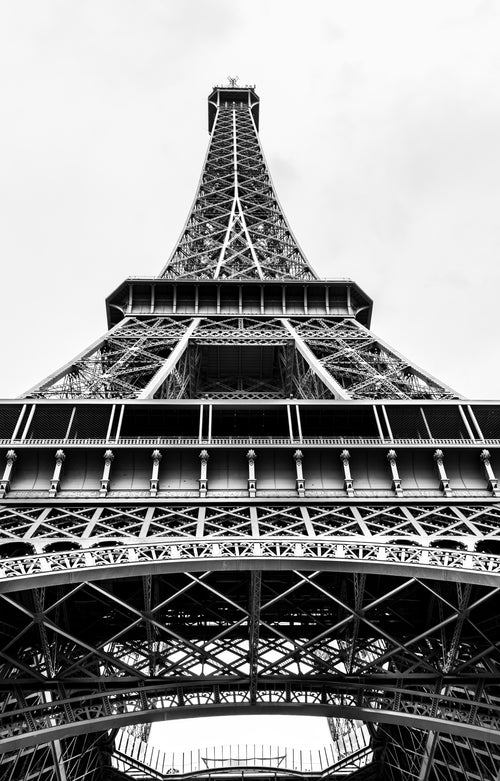 A black-and-white view looking upwards along the Eiffel Tower’s iron structure. Photograph by Anders Jorulf.