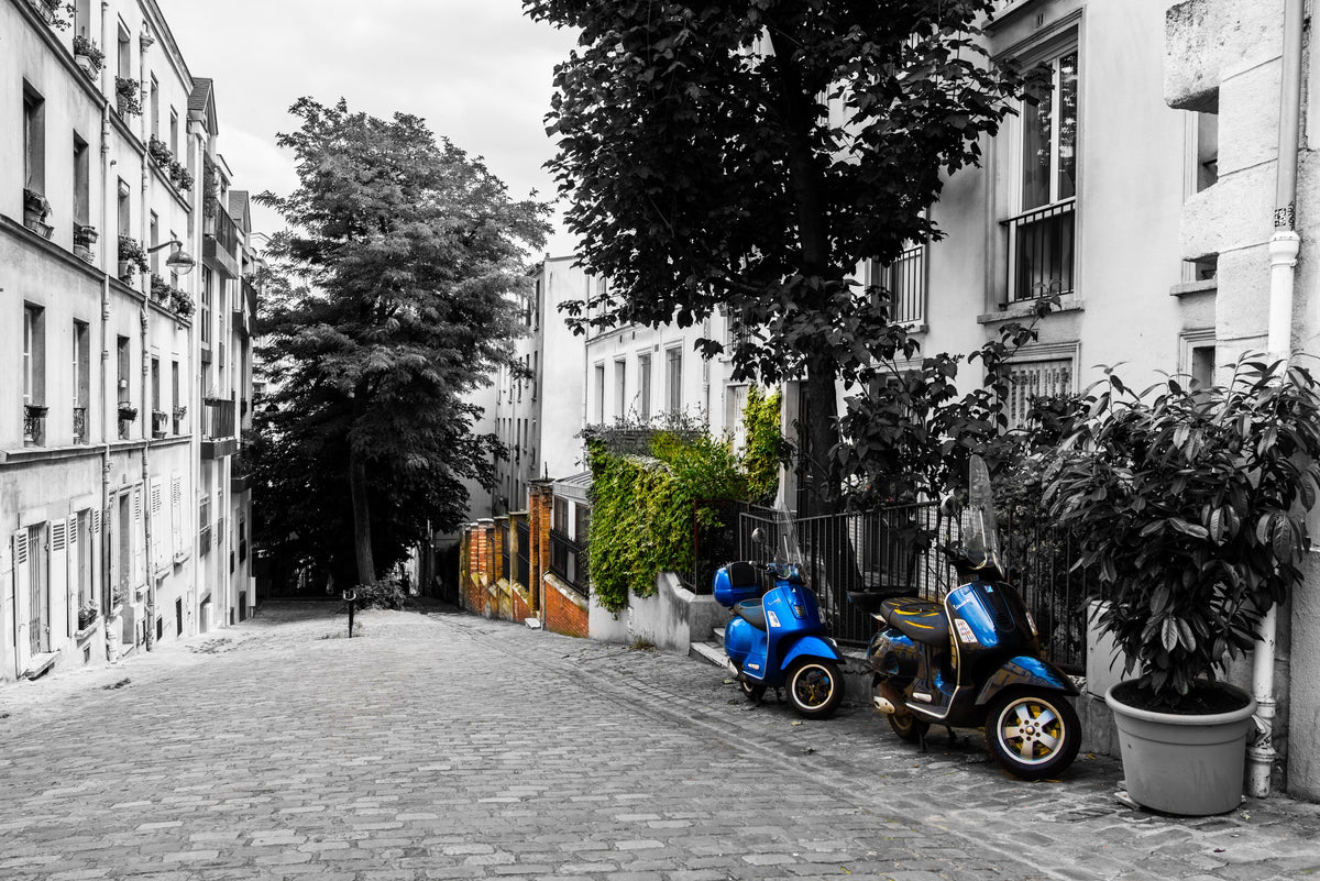 A Paris cobbled street with parked scooters and touches of blue and green. Photograph by Anders Jorulf.